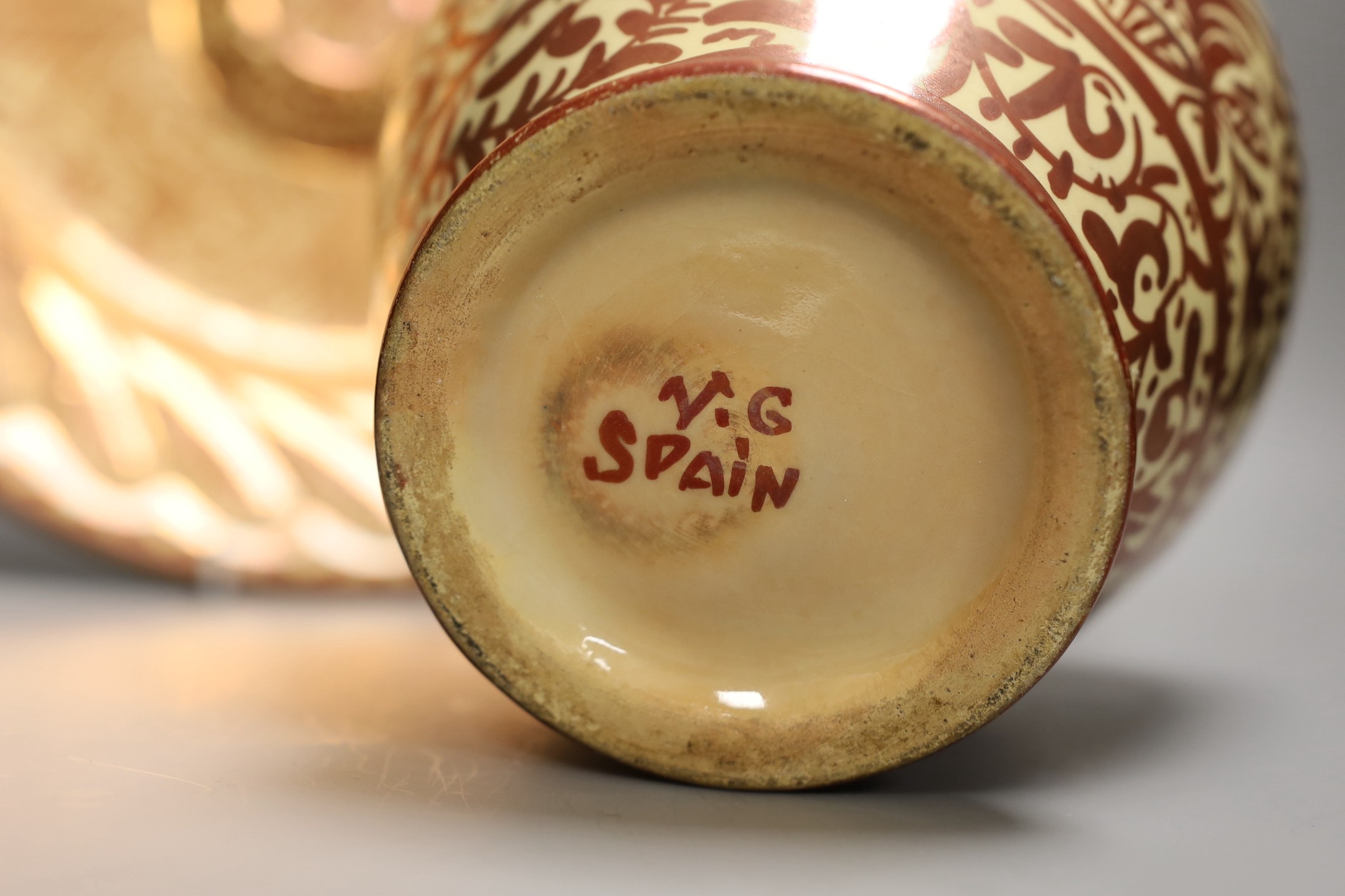 A Hispano Moresque style copper lustre pottery charger and vase, 24cm tall